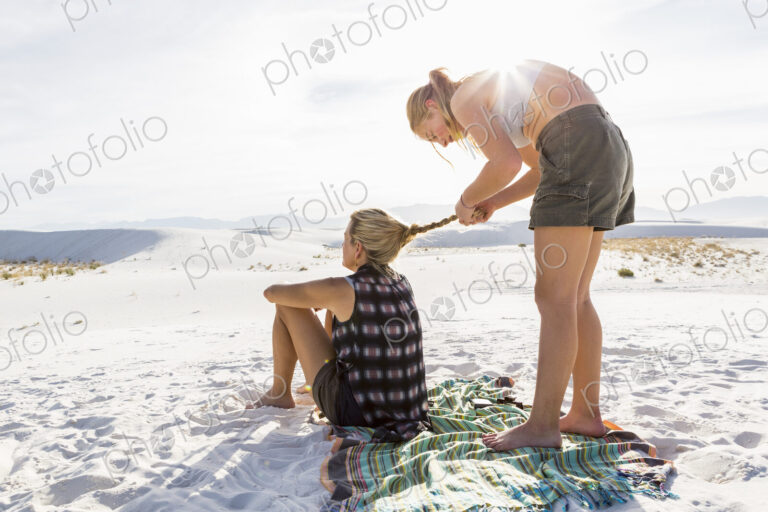 13 year old girl braiding her mothers hair, White Sands Nat'l Monument, NM