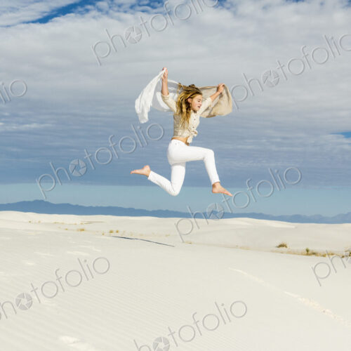 13 year old girl dancing and leaping n mid air in the open space on white sand dunes 13 year old girl dancing and leaping n mid air in the open space on white sand dunes