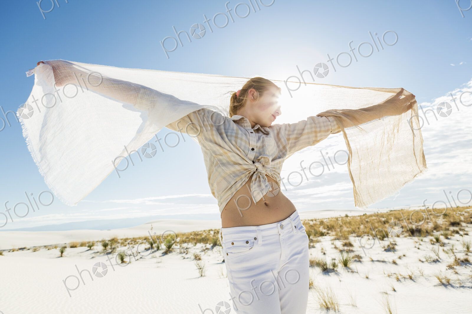 13 year old girl dancing with a shawl in the open space of white sand dunes.