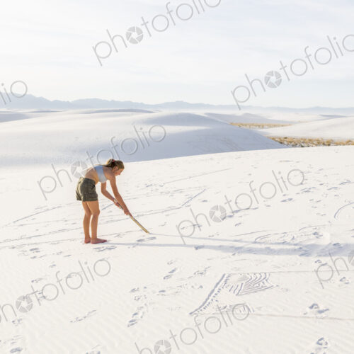 13 year old girl drawing in the sand, White Sands Nat'l Monument, NM