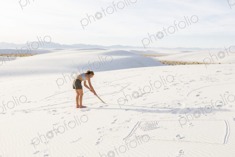 13 year old girl drawing in the sand, White Sands Nat'l Monument, NM