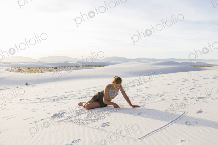 13 year old girl drawing in the sand, White Sands Nat'l Monument, NM