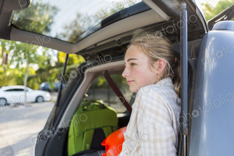 13 year old girl in back of SUV with luggage