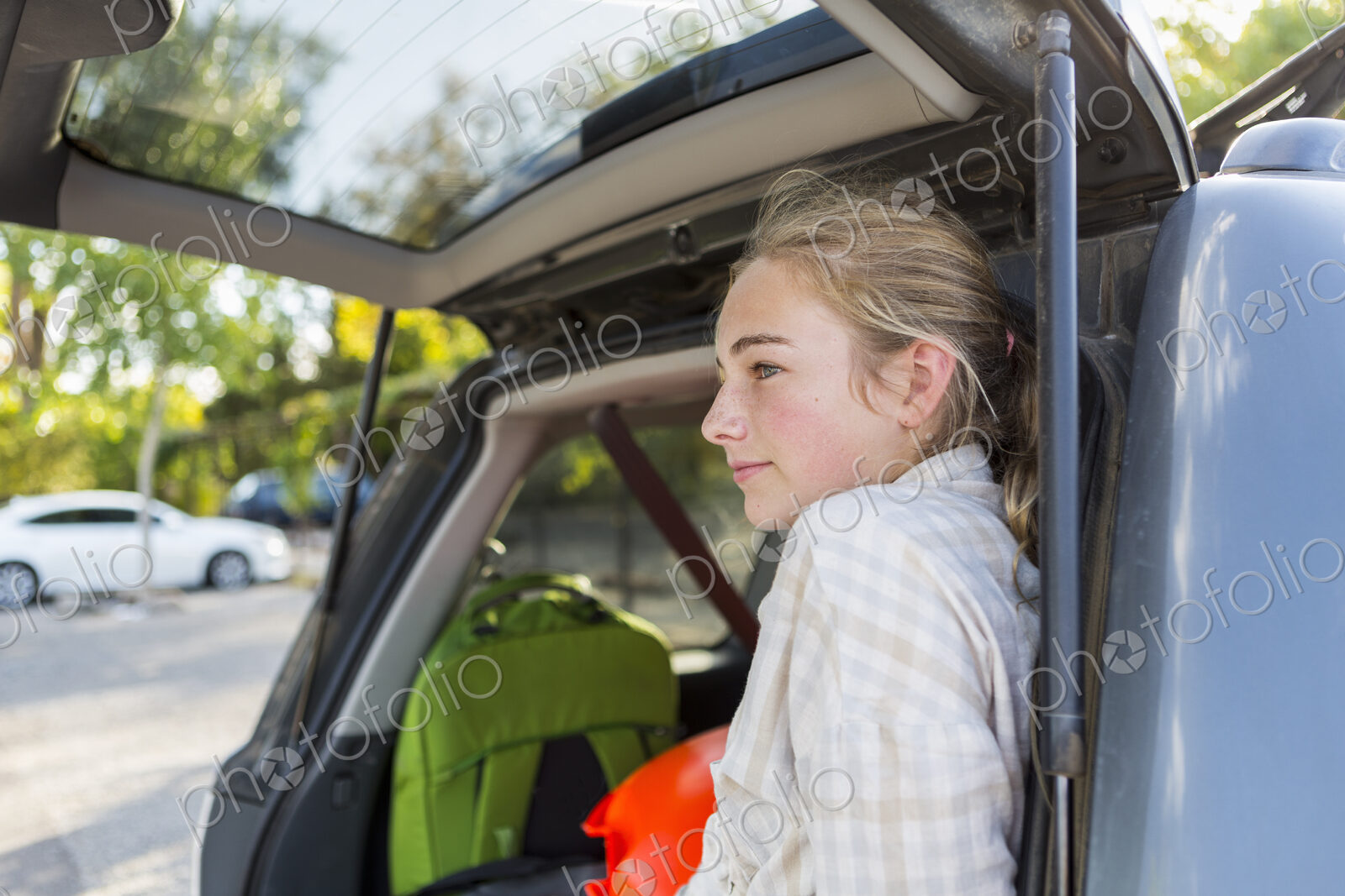13 year old girl in back of SUV with luggage