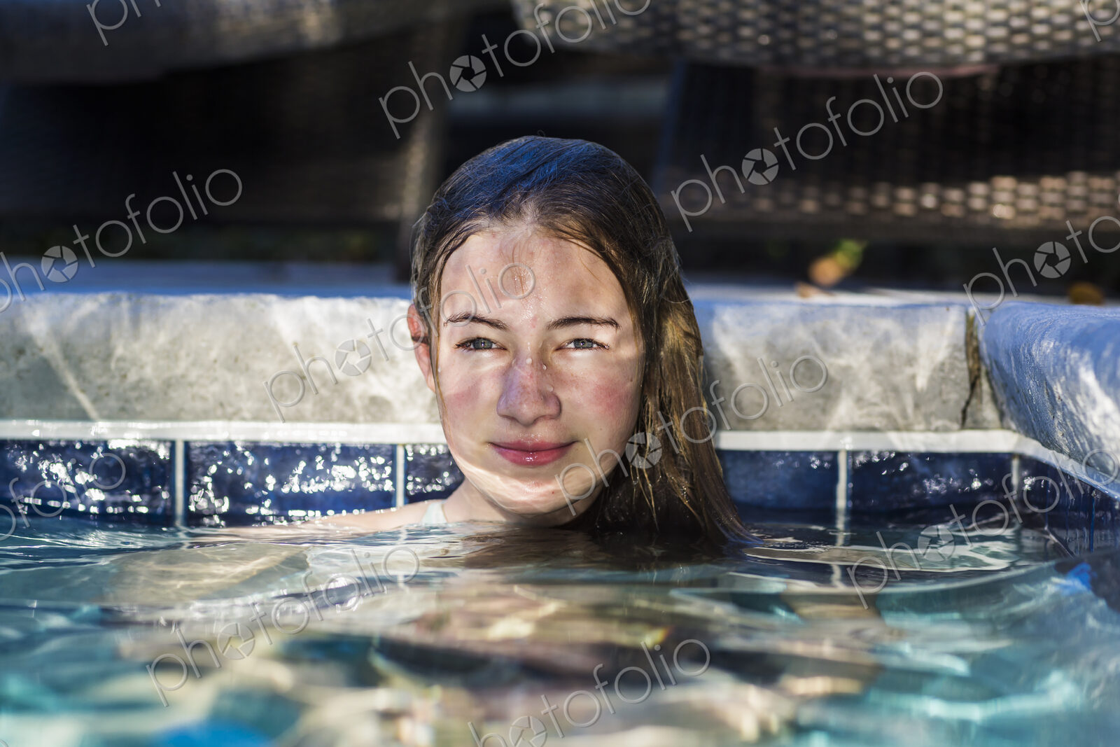 13 year old girl in pool with reflections playing on her face