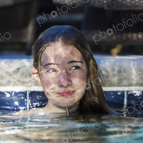 13 year old girl in pool with reflections playing on her face 13 year old girl in pool with reflections playing on her face