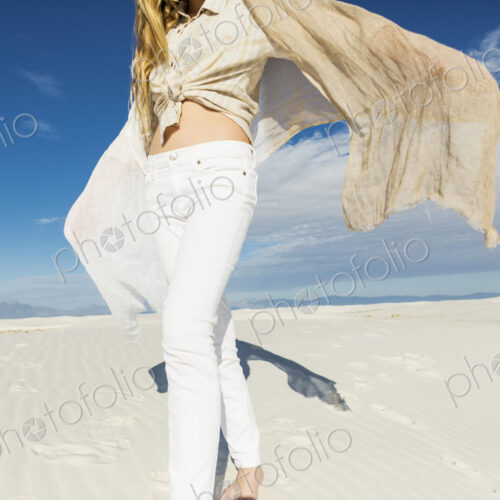13 year old girl leaping and dancing in light white sand sand in a dunes landscape. 13 year old girl leaping and dancing in light white sand sand in a dunes landscape.