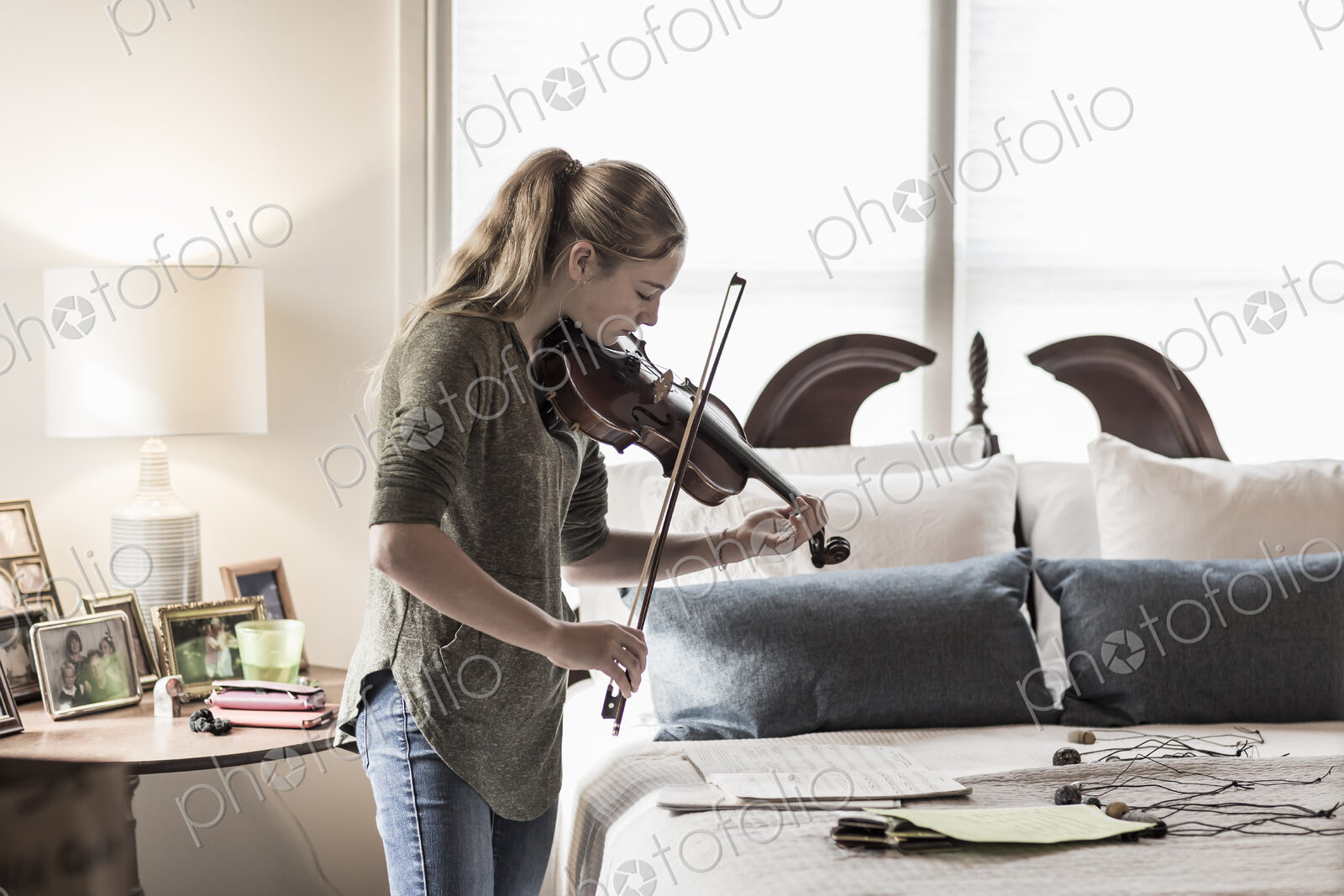 13 year old girl playing violin in bedroom