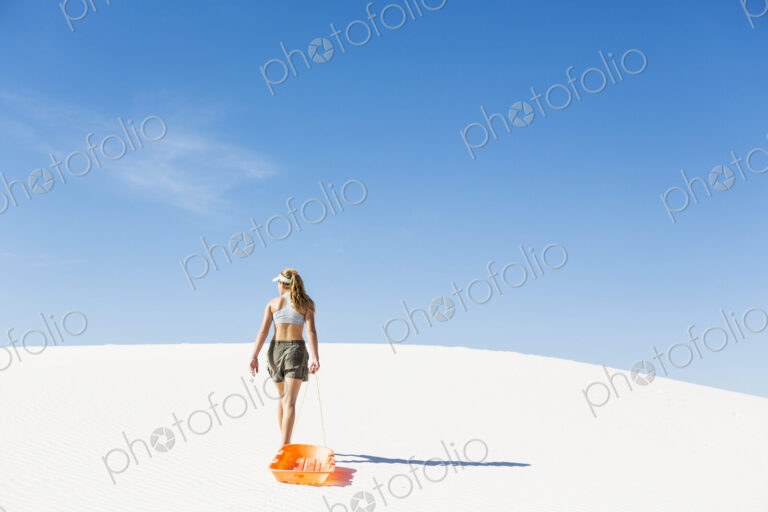 13 year old girl pulling sled in White Sands Nat'l Monument NM