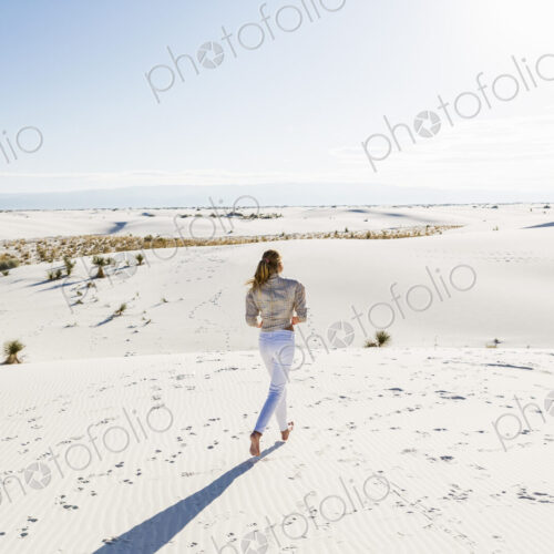 13 year old girl standing looking at a vast open space of sand dunes. 13 year old girl standing looking at a vast open space of sand dunes.