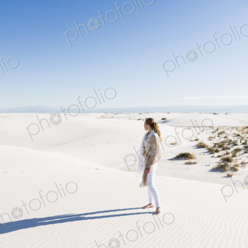 13 year old girl standing looking at a vast open space of sand dunes. 13 year old girl standing looking at a vast open space of sand dunes.