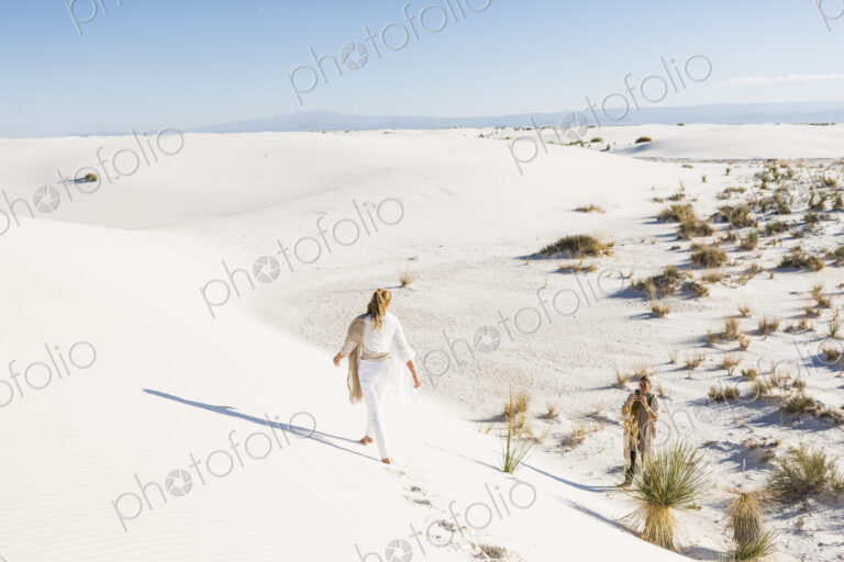 13 year old girl walking across sand dunes leaving footprints