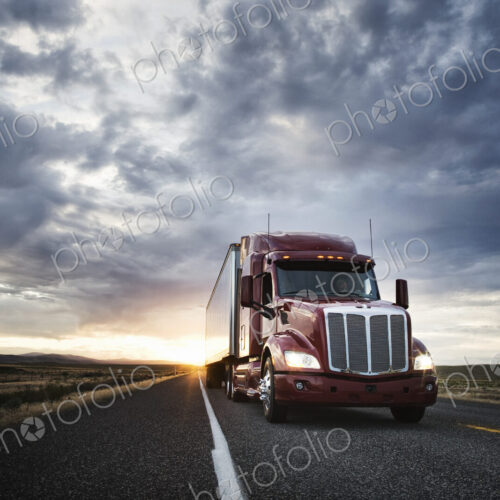 3/4 front view of a commercial truck on the road at sunset in eastern Washington, USA 3/4 front view of a commercial truck on the road at sunset in eastern Washington, USA
