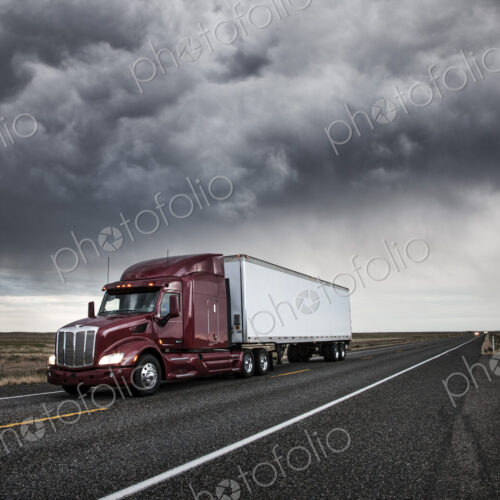 3/4 front view of a commercial truck on the road at sunset in eastern Washington, USA 3/4 front view of a commercial truck on the road at sunset in eastern Washington, USA