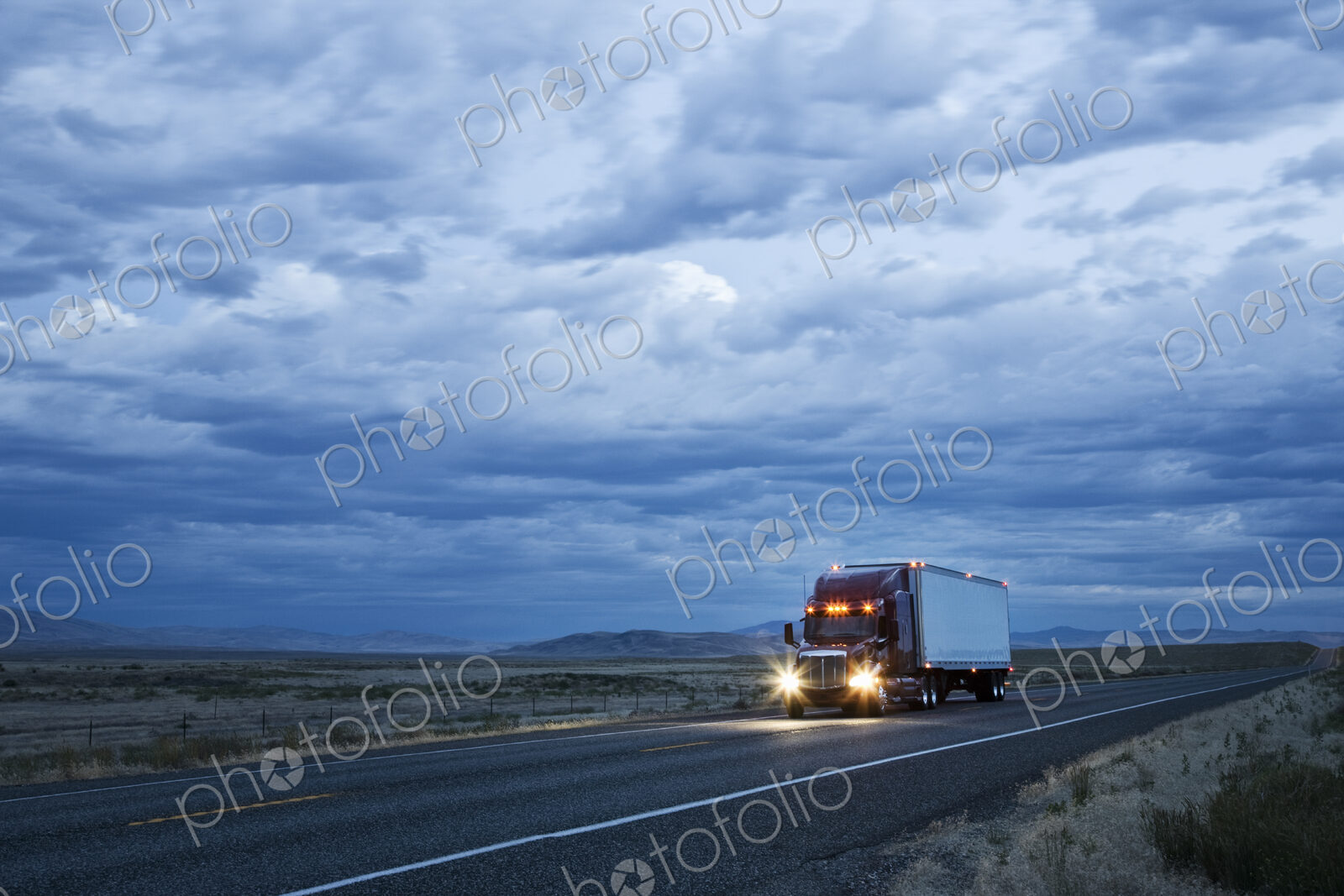 3/4 front view of a commercial truck on the road in the early evening in eastern…