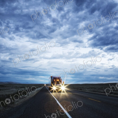 3/4 front view of a commercial truck on the road in the early evening in eastern… 3/4 front view of a commercial truck on the road in the early evening in eastern…