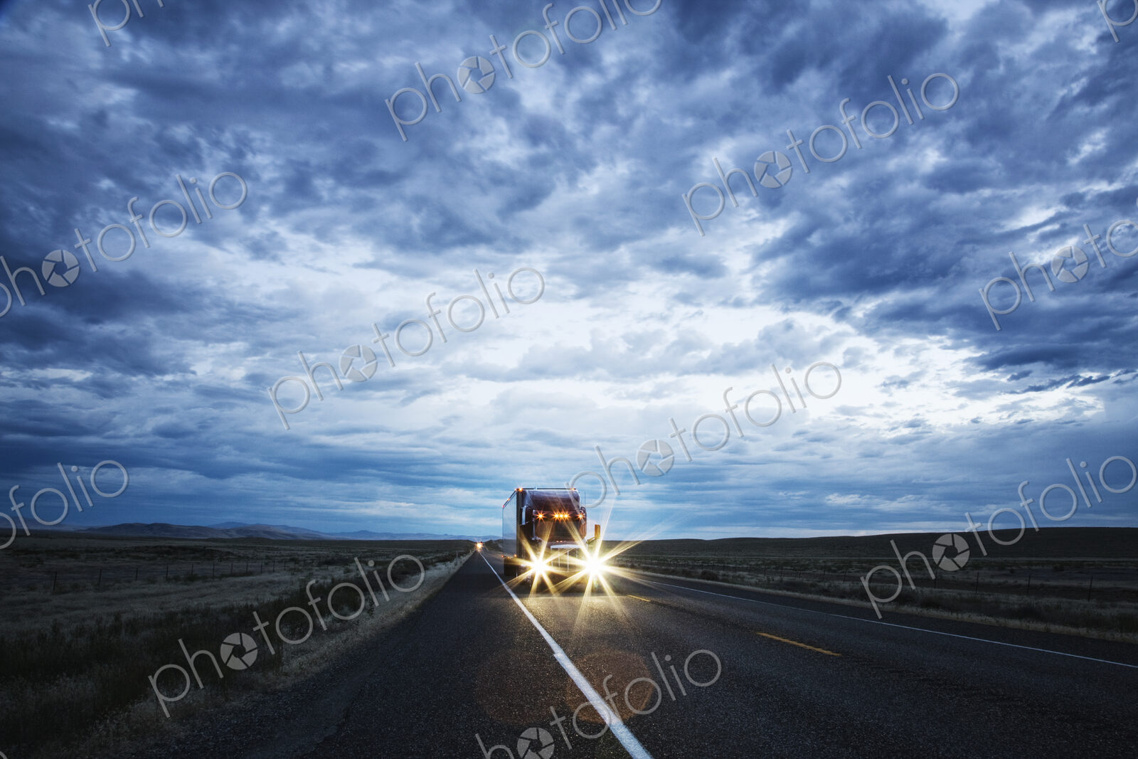 3/4 front view of a commercial truck on the road in the early evening in eastern…
