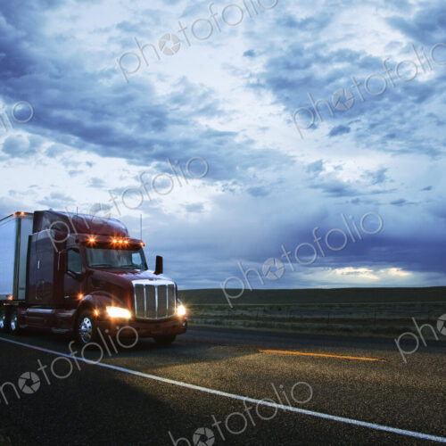3/4 front view of a commercial truck on the road in the early evening in eastern…