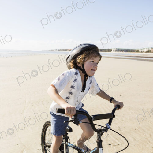 6 year old boy biking on beach, St. Simon's Island, Georgia