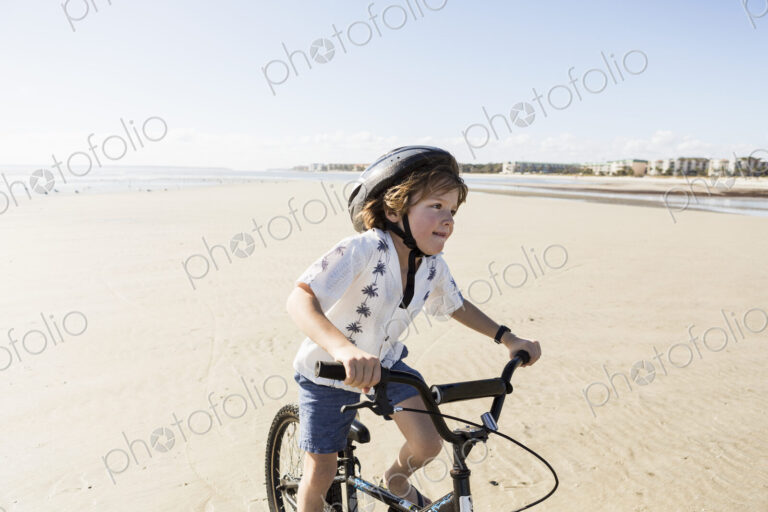 6 year old boy biking on beach, St. Simon's Island, Georgia