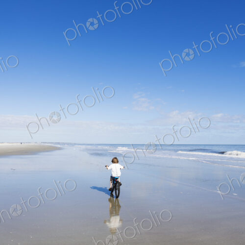 6 year old boy biking on beach, St. Simon's Island, Georgia
