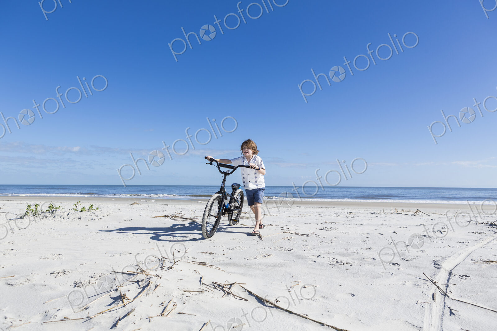 6 year old boy biking on beach, St. Simon’s Island, Georgia