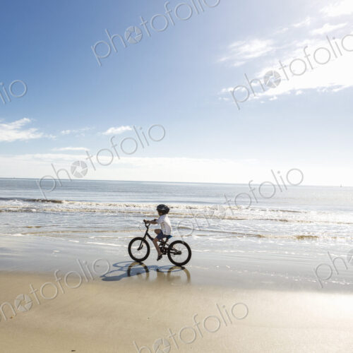 6 year old boy biking on beach, St. Simon's Island, Georgia