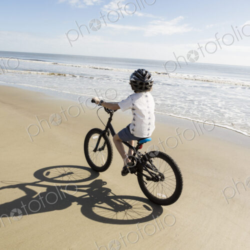 6 year old boy biking on beach, St. Simon's Island, Georgia
