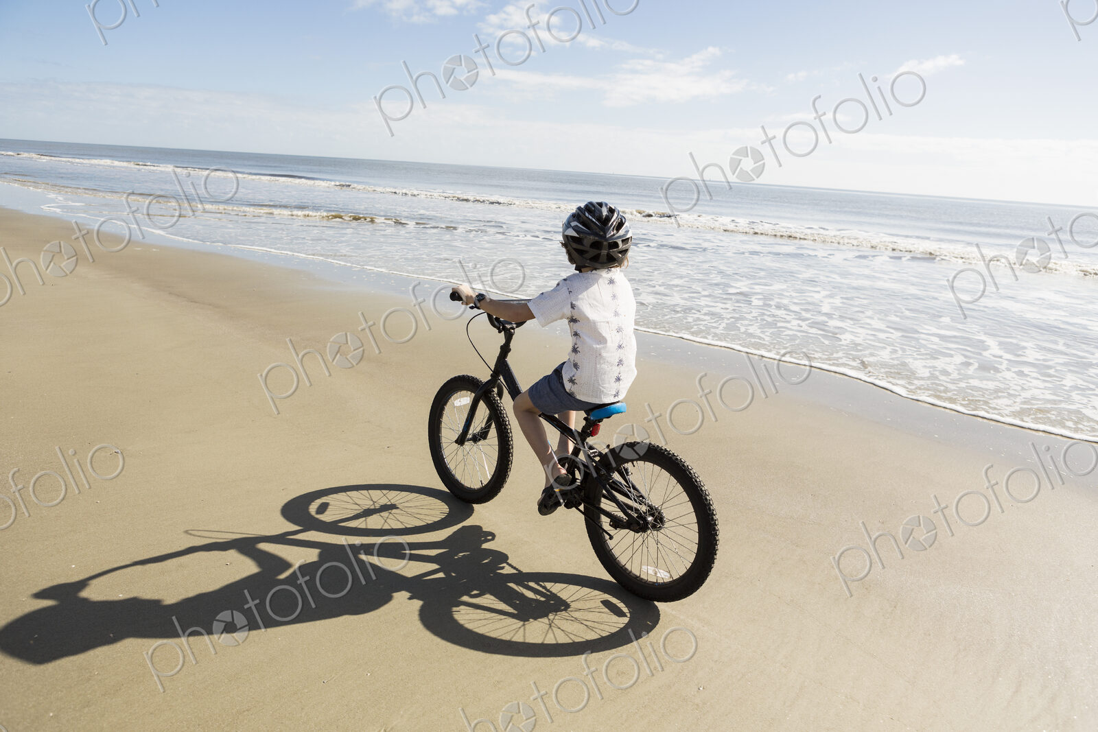 6 year old boy biking on beach, St. Simon’s Island, Georgia