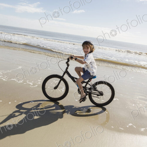 6 year old boy biking on beach, St. Simon's Island, Georgia