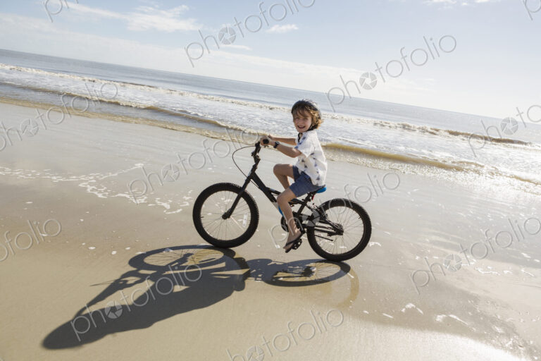 6 year old boy biking on beach, St. Simon's Island, Georgia
