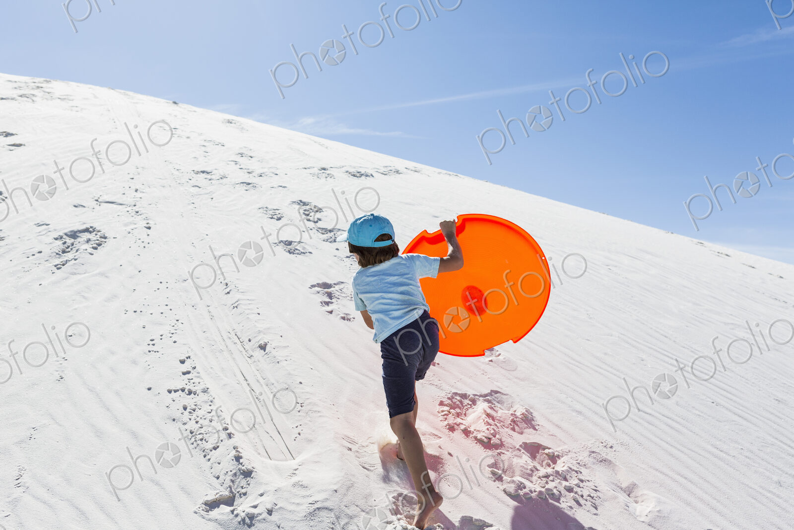 6 year old boy climbing sand dune
