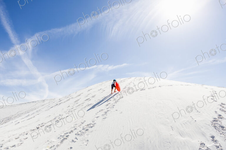 6 year old boy climbing sand dune