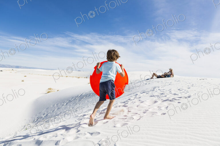 6 year old boy climbing sand dune