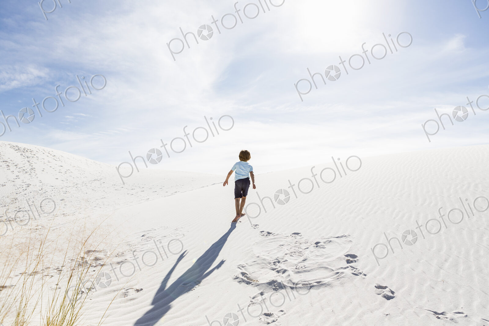 6 year old boy climbing sand dune
