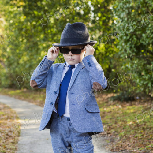 6 year old boy dressed in suit and wearing fedora, in driveway 6 year old boy dressed in suit and wearing fedora, in driveway