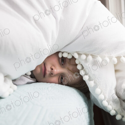 6 year old boy in bed with covers over his head