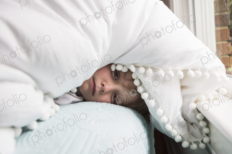 6 year old boy in bed with covers over his head