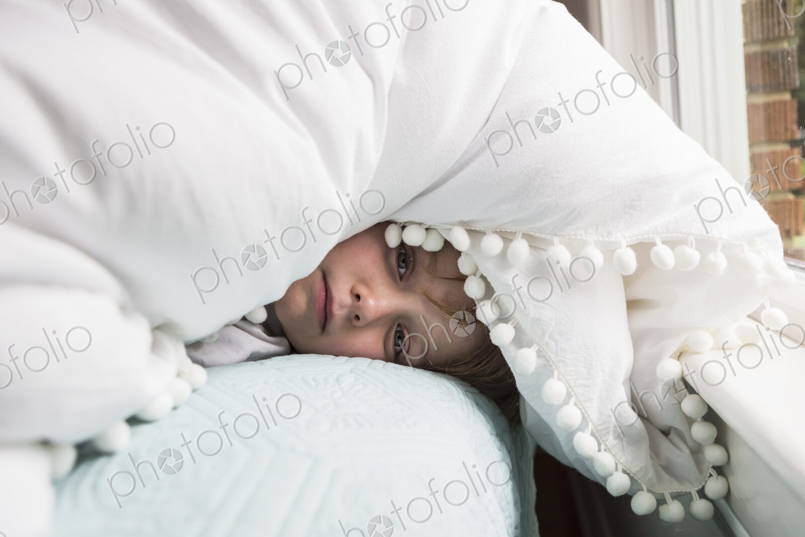 6 year old boy in bed with covers over his head