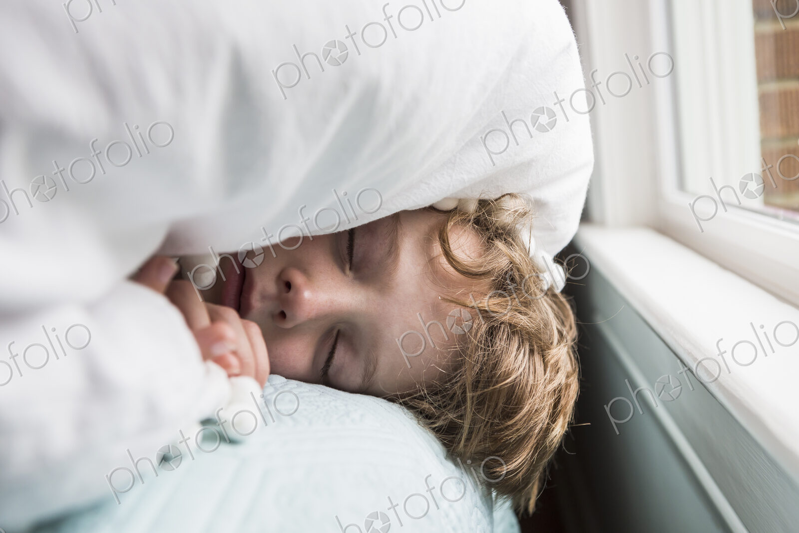 6 year old boy in bed with covers over his head