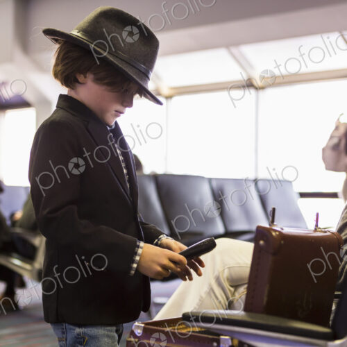 6 year old boy looking at his briefcase in airport 6 year old boy looking at his briefcase in airport