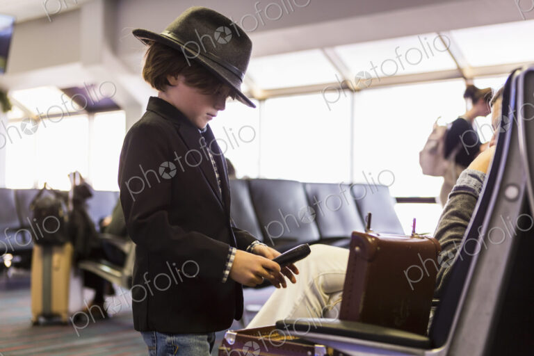 6 year old boy looking at his briefcase in airport