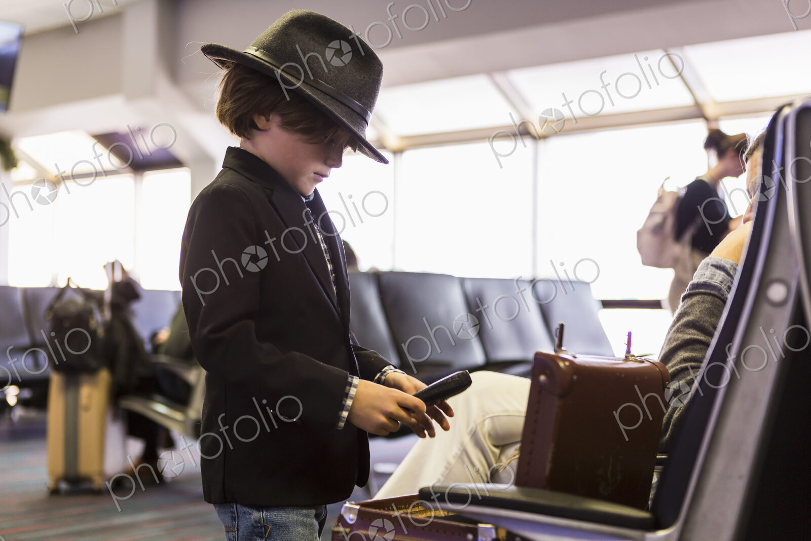 6 year old boy looking at his briefcase in airport