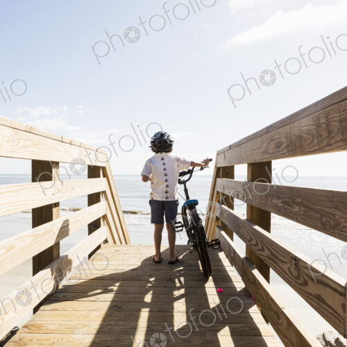 6 year old boy on wooden bridge with his bike