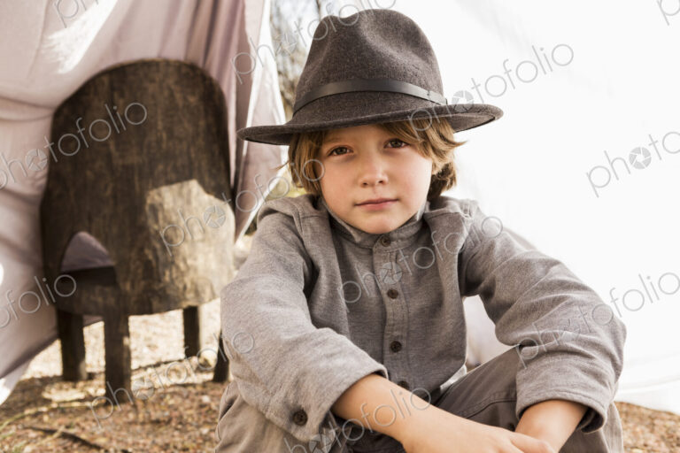 6 year old boy playing in an outdoor tent made of sheets