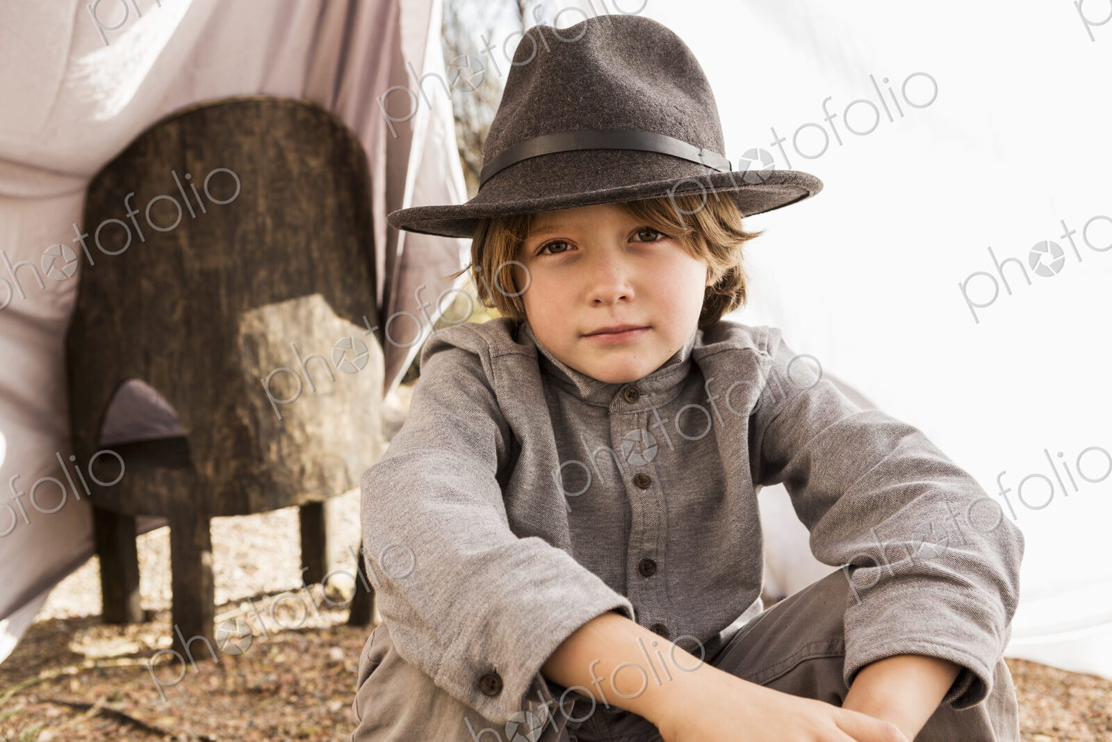 6 year old boy playing in an outdoor tent made of sheets
