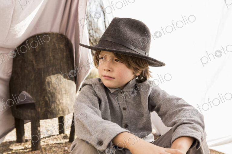 6 year old boy playing in an outdoor tent made of sheets