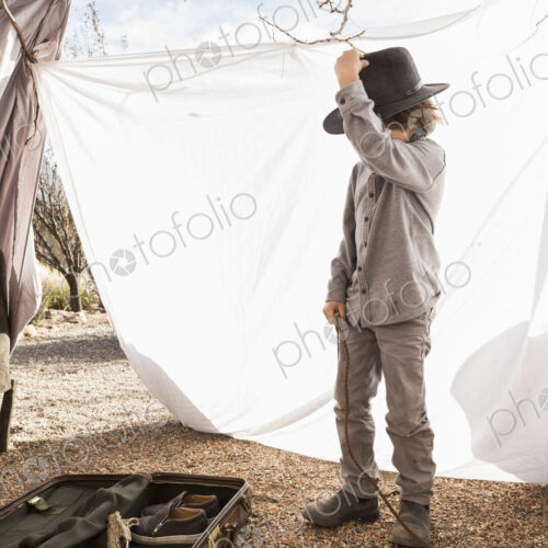 6 year old boy playing in an outdoor tent made of sheets 6 year old boy playing in an outdoor tent made of sheets