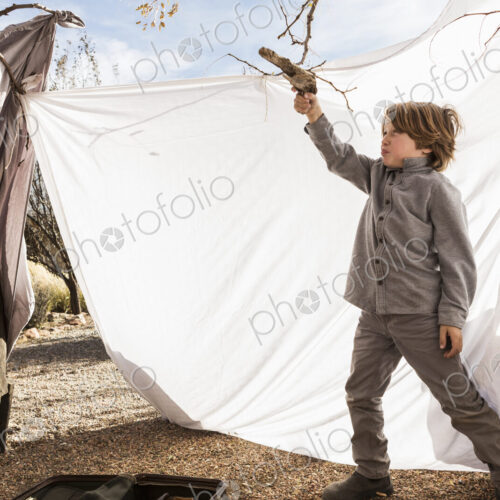 6 year old boy playing in an outdoor tent made of sheets 6 year old boy playing in an outdoor tent made of sheets