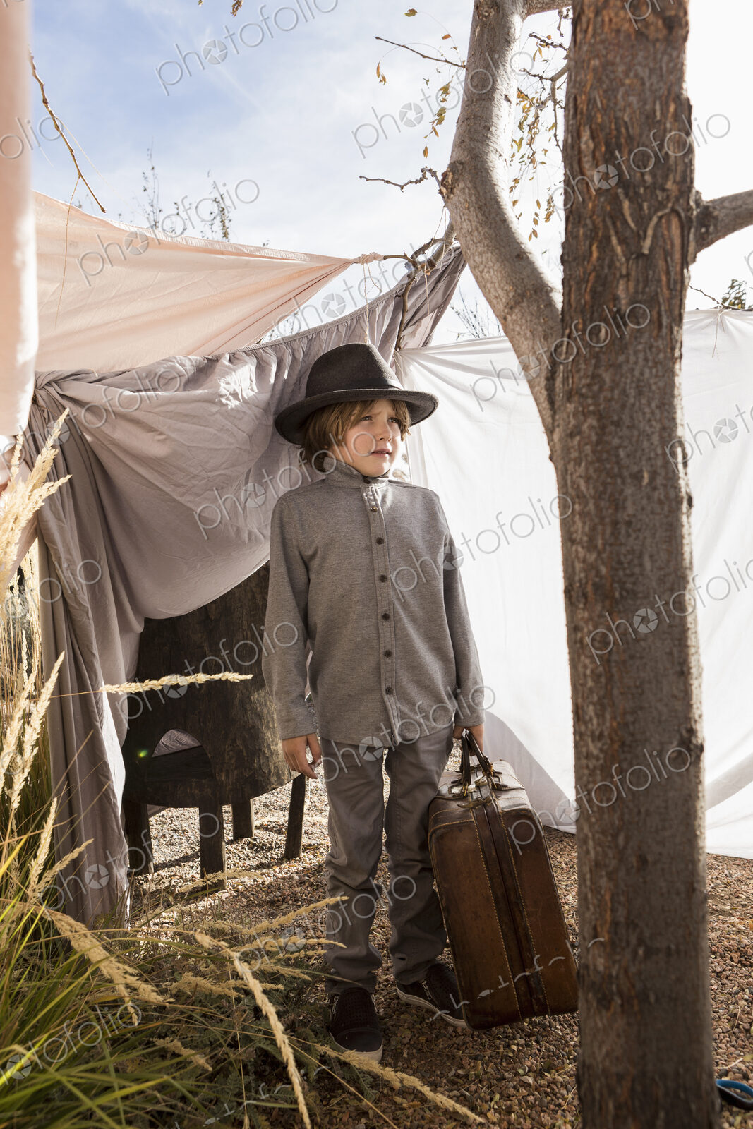 6 year old boy playing in an outdoor tent made of sheets